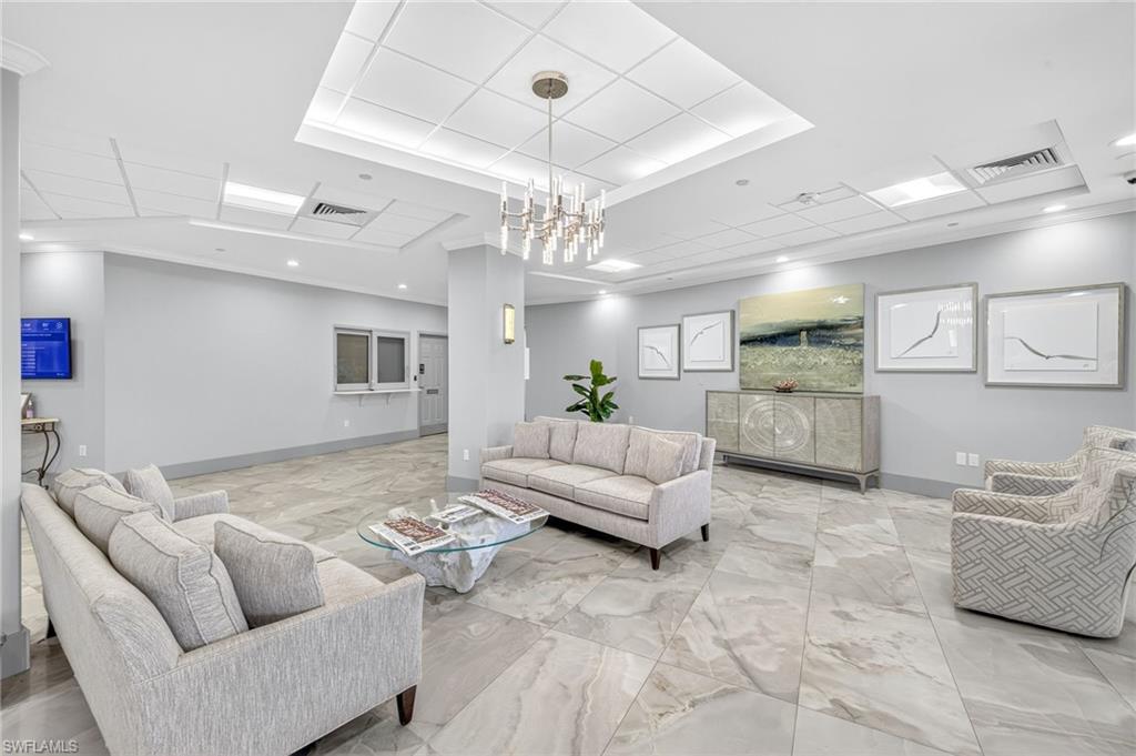 58 North Collier Boulevard, Unit 1606 Marco Island, FL 34145 - Photo 24 of 37 a living room with furniture and a chandelier