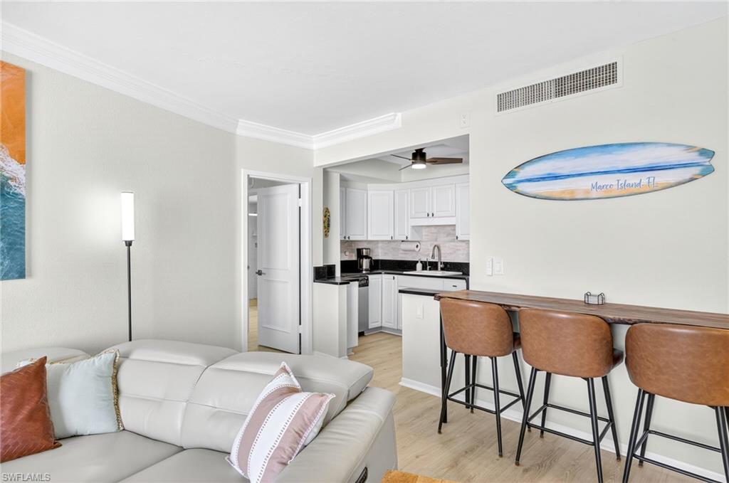 58 North Collier Boulevard, Unit 1606 Marco Island, FL 34145 - Photo 6 of 37 a living room with stainless steel appliances furniture a refrigerator and a dining table