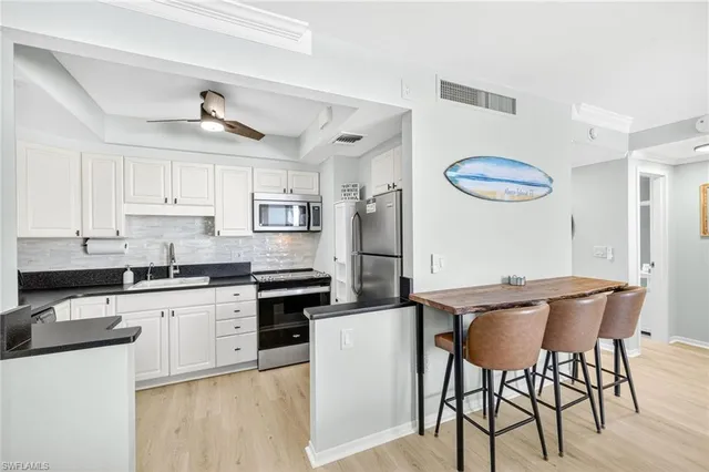 a kitchen with stainless steel appliances granite countertop a white cabinets and a stove top oven