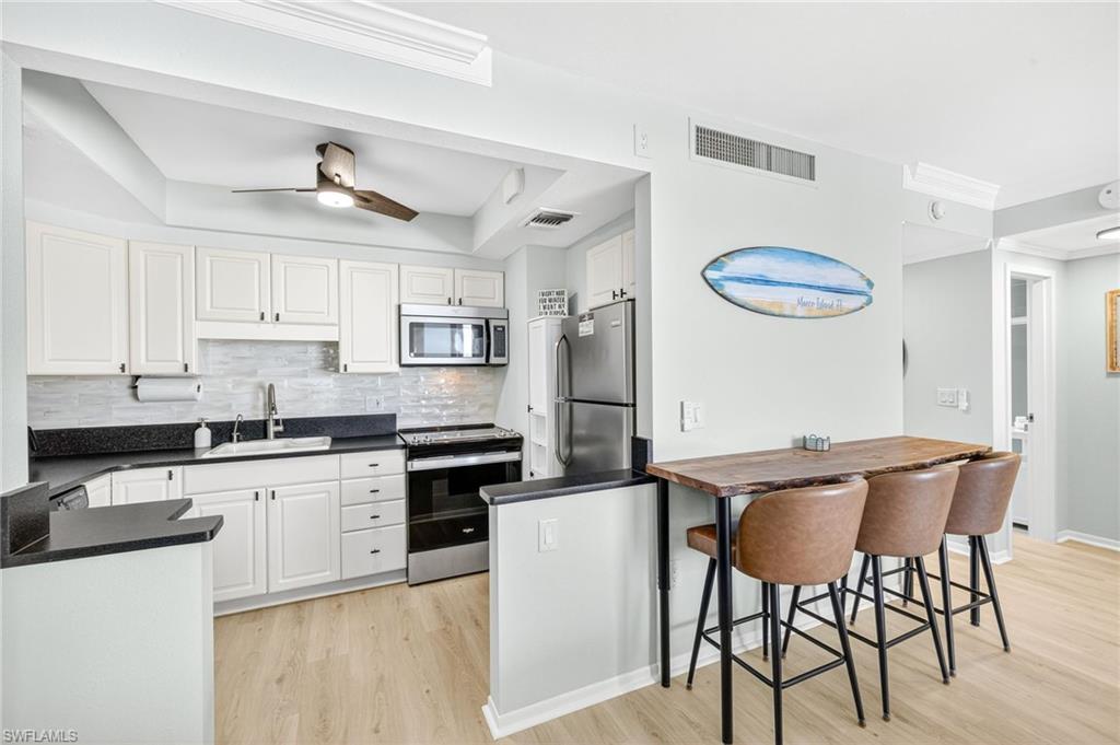 58 North Collier Boulevard, Unit 1606 Marco Island, FL 34145 - Photo 7 of 37 a kitchen with stainless steel appliances granite countertop a white cabinets and a stove top oven