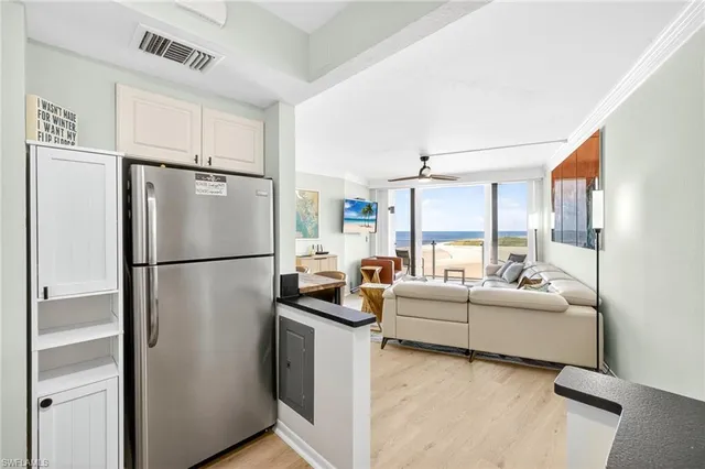 a kitchen with refrigerator a stove and white cabinets