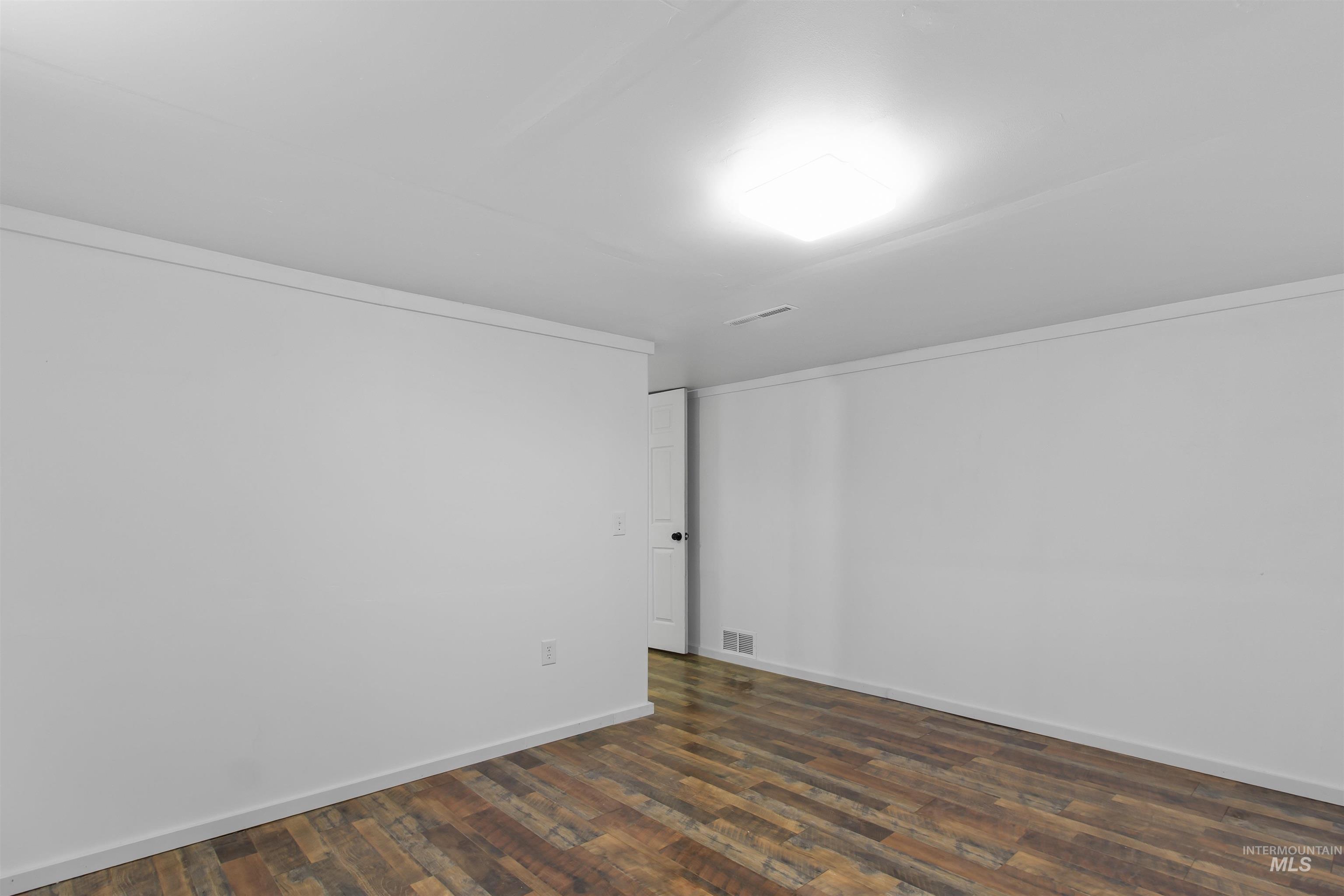 412 Madison Street Twin Falls, ID 83301 - Photo 20 of 42 Spare room featuring dark wood-style flooring and crown molding