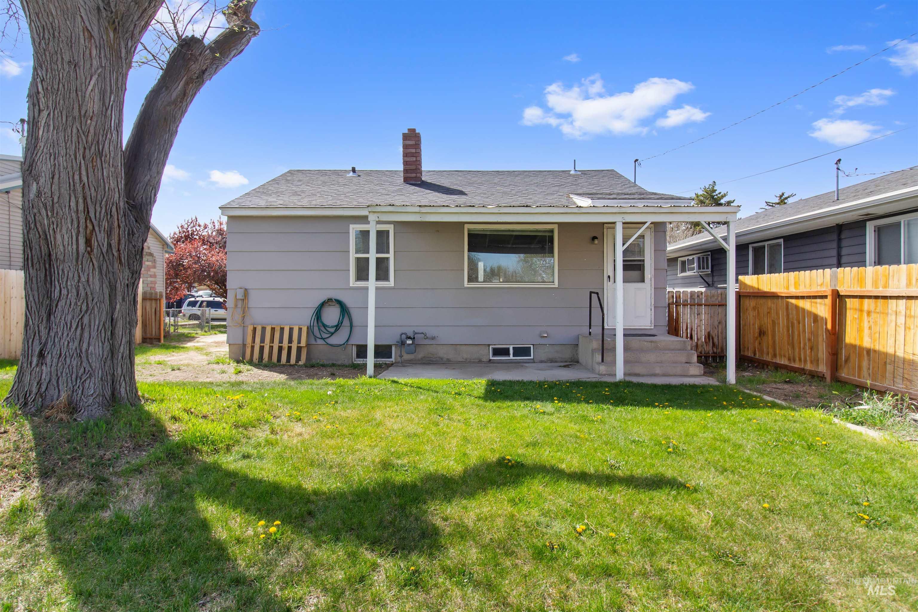 412 Madison Street Twin Falls, ID 83301 - Photo 26 of 42 Rear view of house with a chimney, roof with shingles, and a patio area