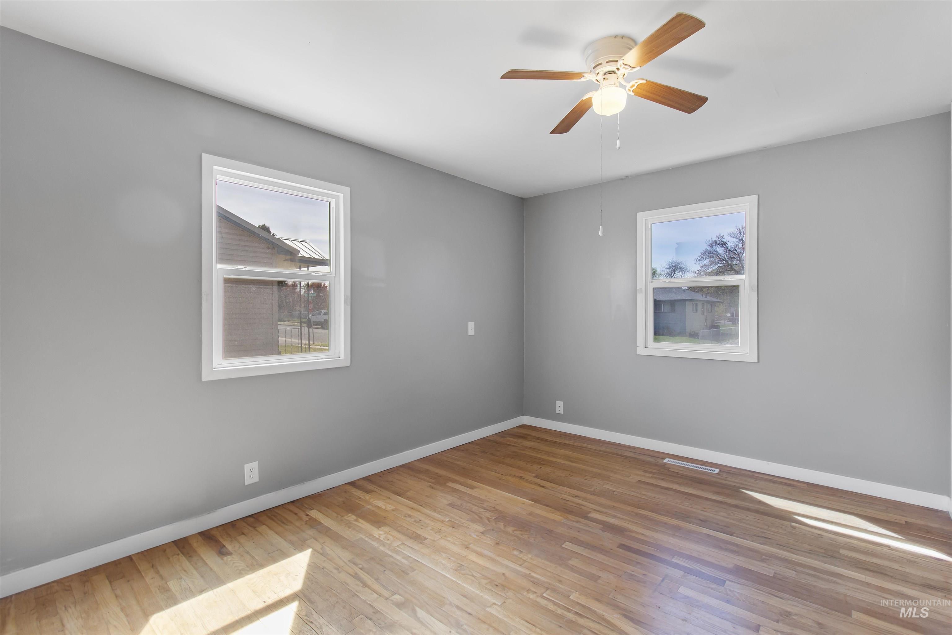 412 Madison Street Twin Falls, ID 83301 - Photo 3 of 42 Unfurnished room featuring light wood-style floors and a ceiling fan