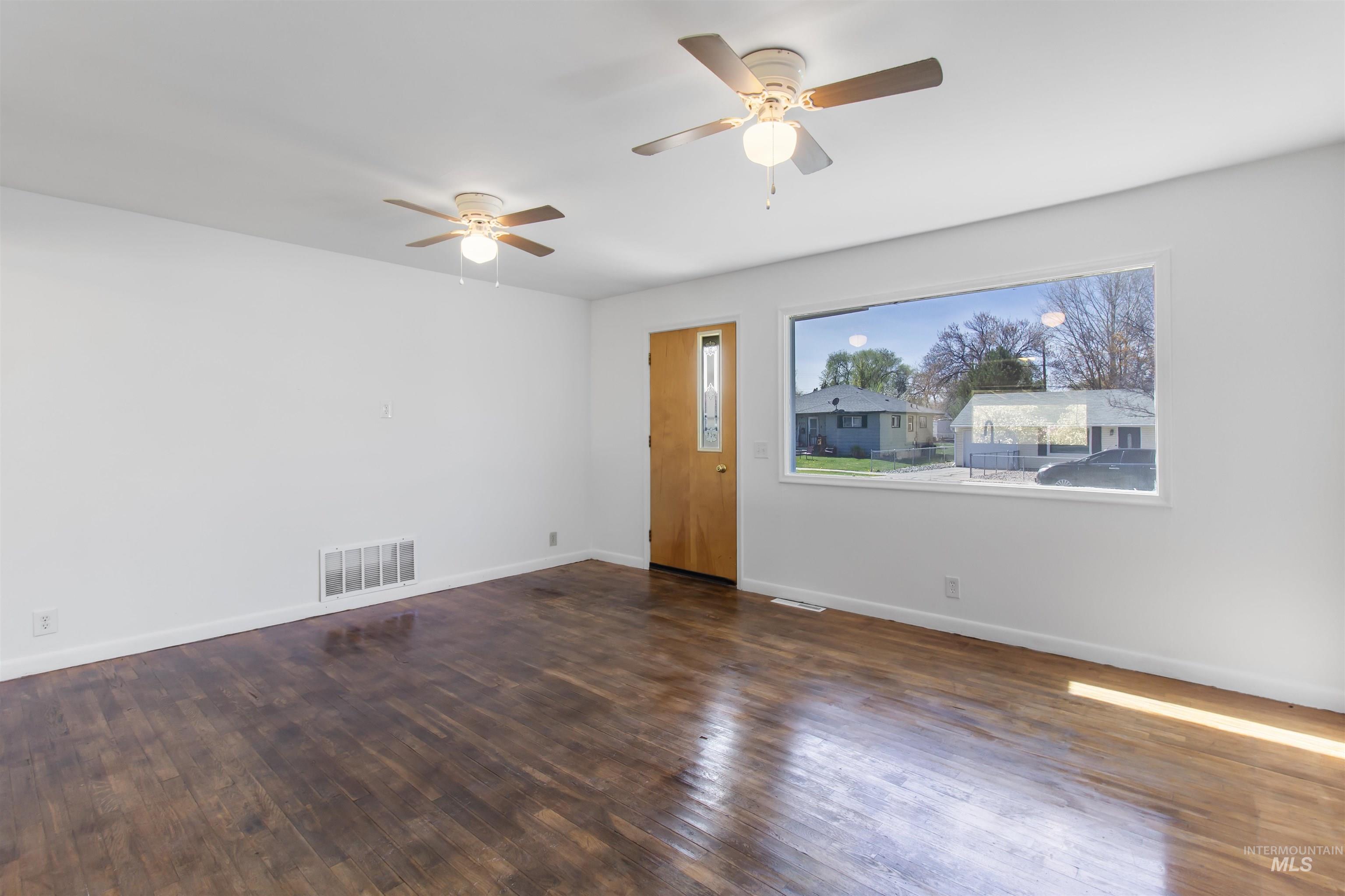 412 Madison Street Twin Falls, ID 83301 - Photo 4 of 42 Unfurnished living room with dark wood-style flooring and a ceiling fan