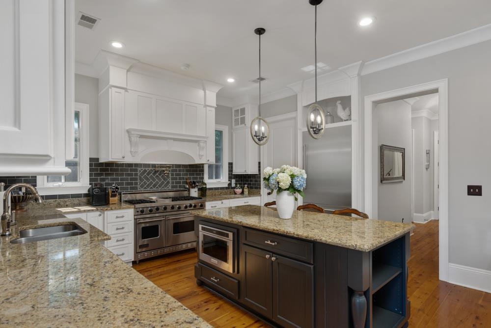 5097 Cole Road Memphis, TN 38117 - Photo 7 of 25 a kitchen with a stove a sink a kitchen island with wooden cabinets and floor