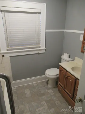 a bathroom with a toilet a sink and a mirror