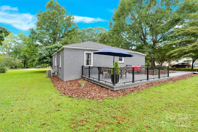 a view of a house with a yard and sitting area