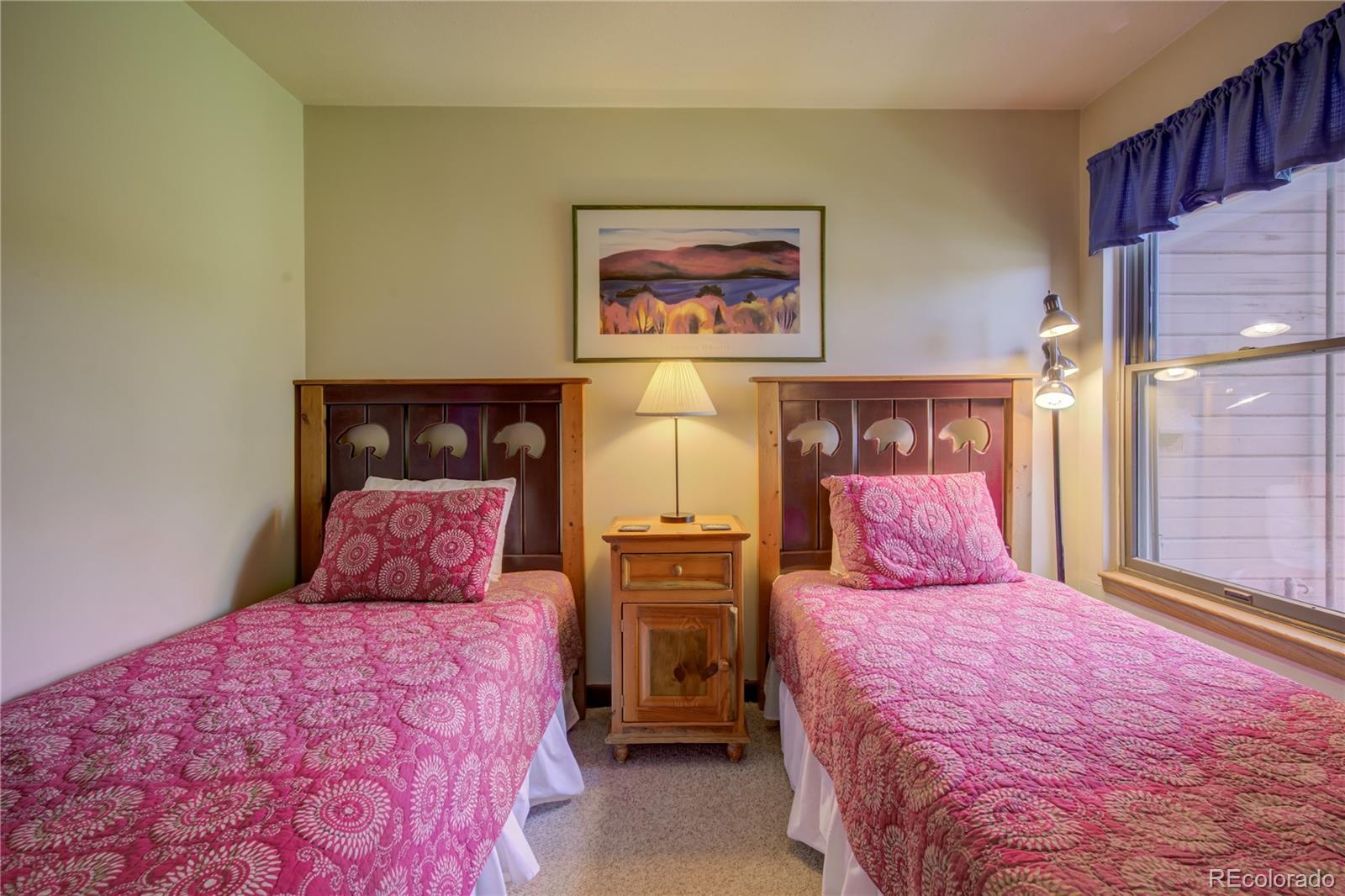 2015 Walton Creek Road, Unit 114 Steamboat Springs, CO 80487 - Photo 18 of 29 a bedroom with a bed and a painting on the wall