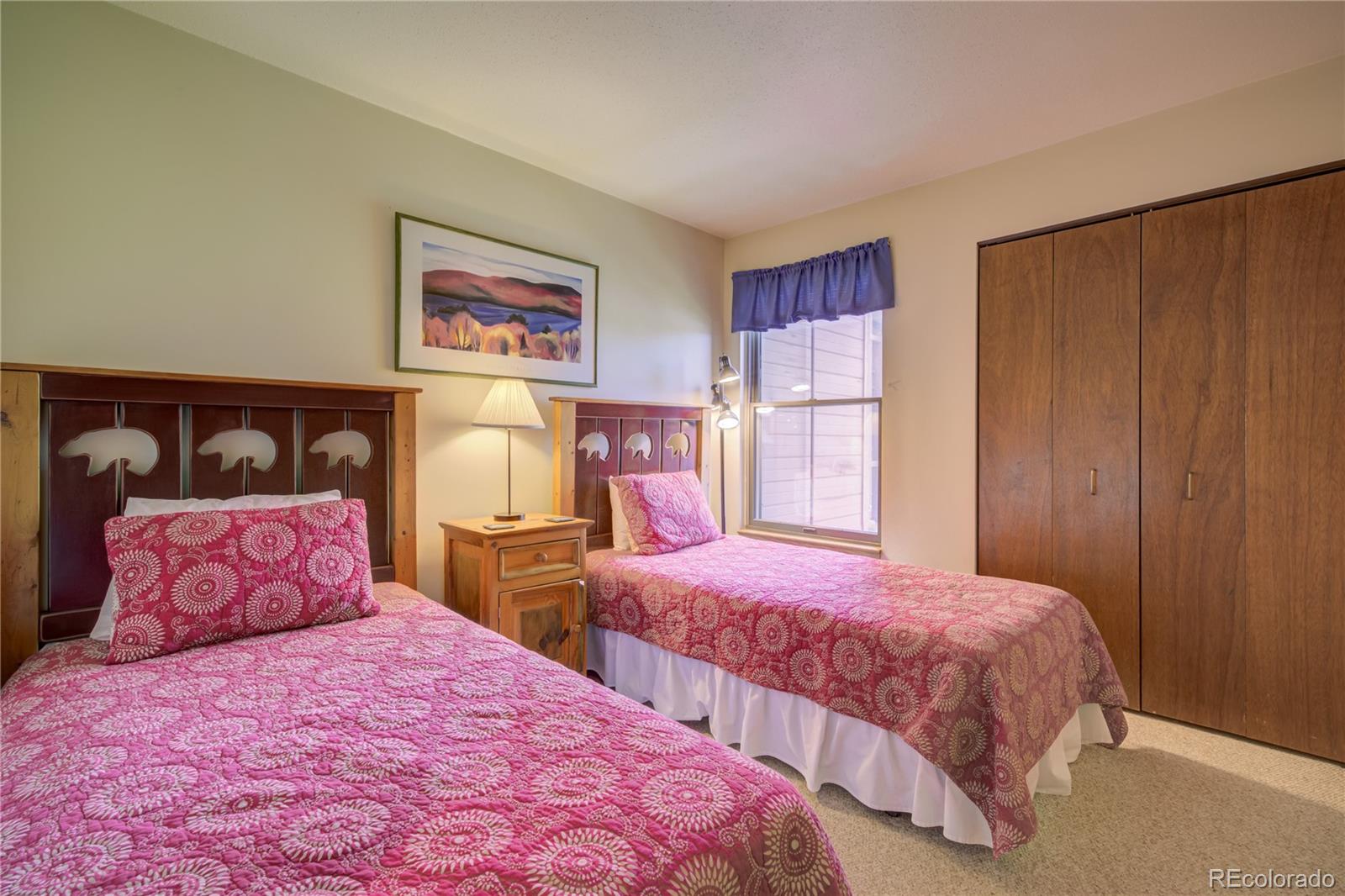 2015 Walton Creek Road, Unit 114 Steamboat Springs, CO 80487 - Photo 19 of 29 a bedroom with two beds and a painting on the wall