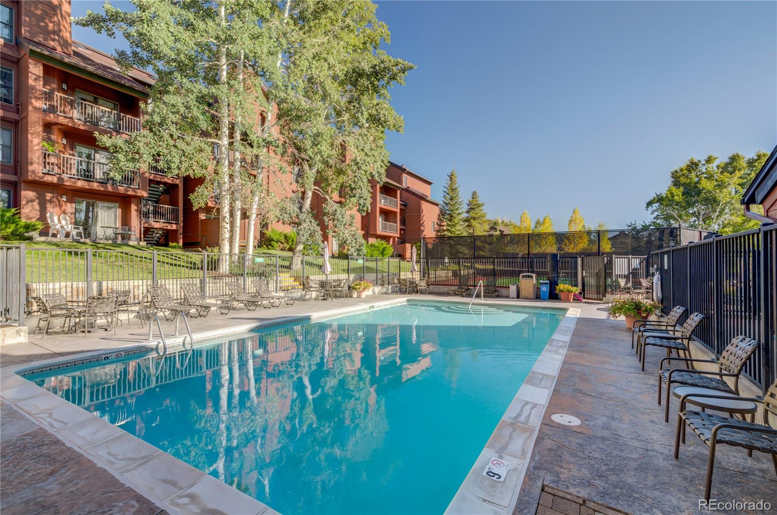 2015 Walton Creek Road, Unit 114 Steamboat Springs, CO 80487 - Photo 24 of 29 a swimming pool with outdoor seating and yard