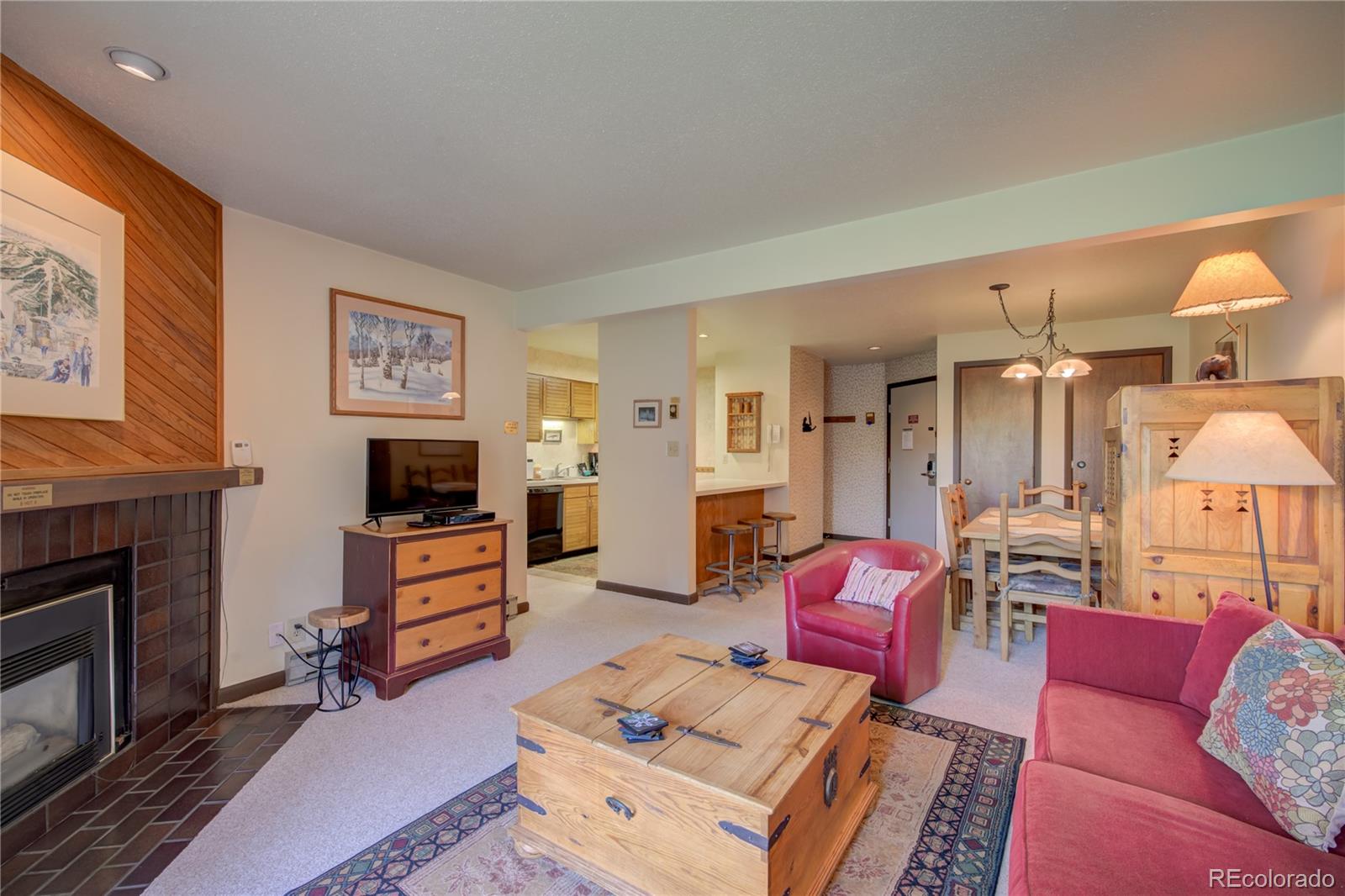 2015 Walton Creek Road, Unit 114 Steamboat Springs, CO 80487 - Photo 3 of 29 a living room with furniture a flat screen tv and a fireplace