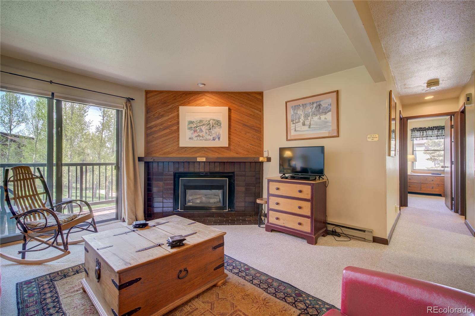 2015 Walton Creek Road, Unit 114 Steamboat Springs, CO 80487 - Photo 4 of 29 a living room with furniture and a fireplace