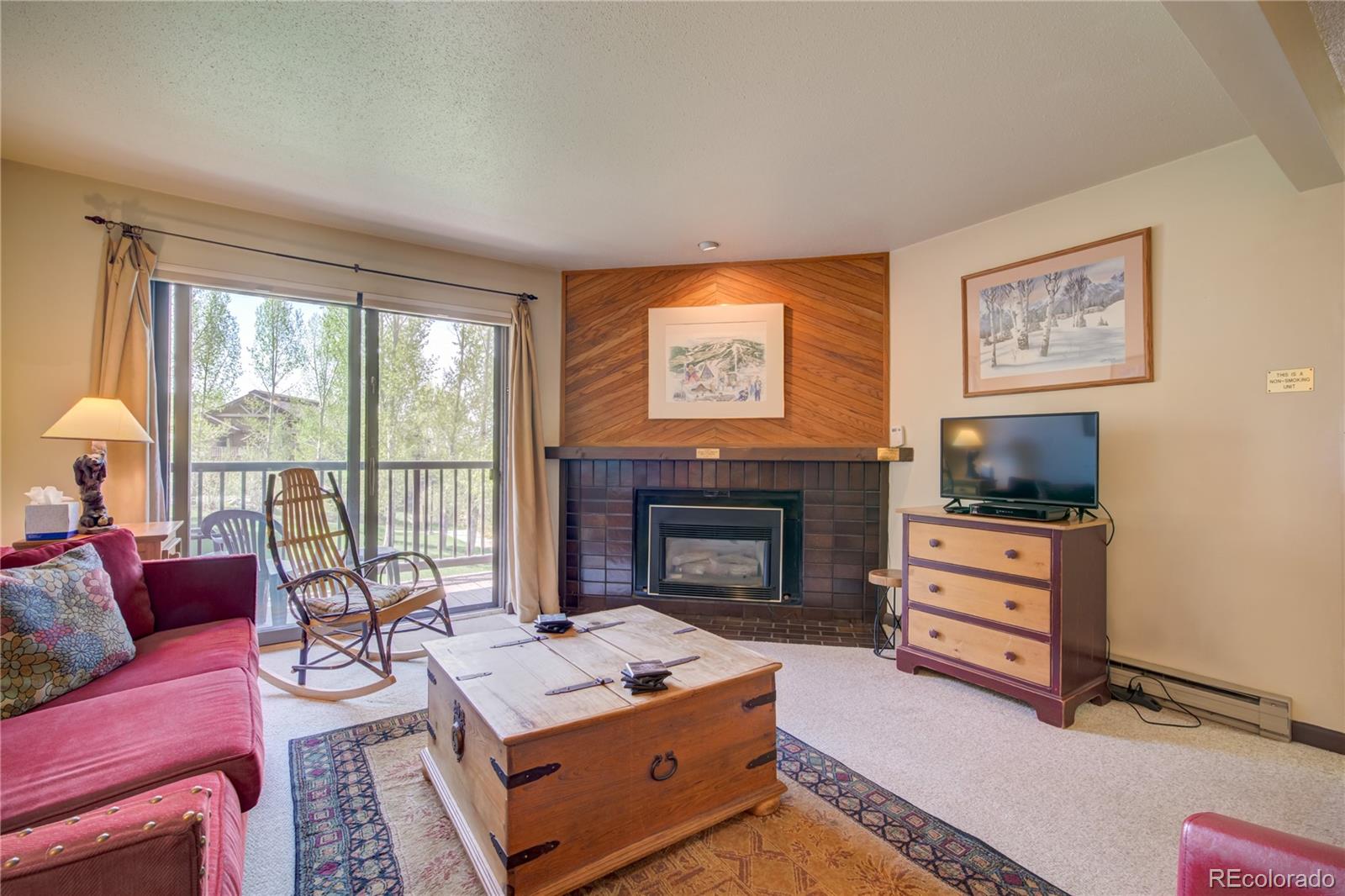 2015 Walton Creek Road, Unit 114 Steamboat Springs, CO 80487 - Photo 6 of 29 a living room with furniture a flat screen tv and a fireplace