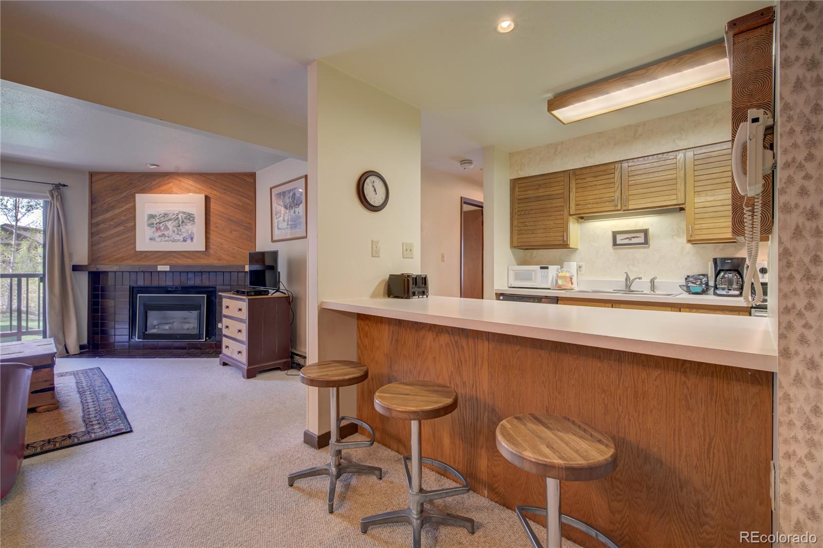 2015 Walton Creek Road, Unit 114 Steamboat Springs, CO 80487 - Photo 7 of 29 a living room with furniture a fireplace and a large window