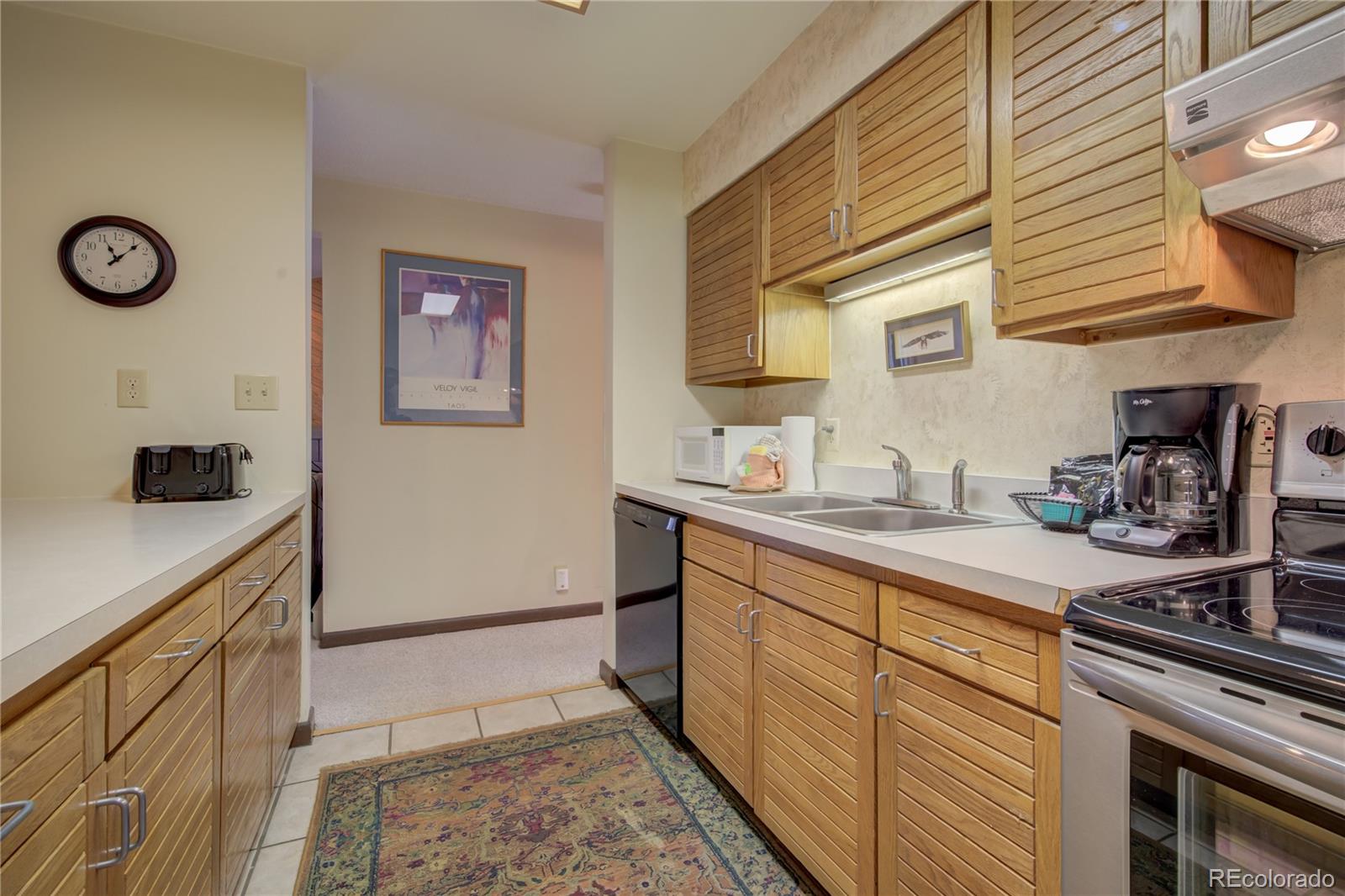 2015 Walton Creek Road, Unit 114 Steamboat Springs, CO 80487 - Photo 9 of 29 a kitchen with stainless steel appliances granite countertop a sink and cabinets