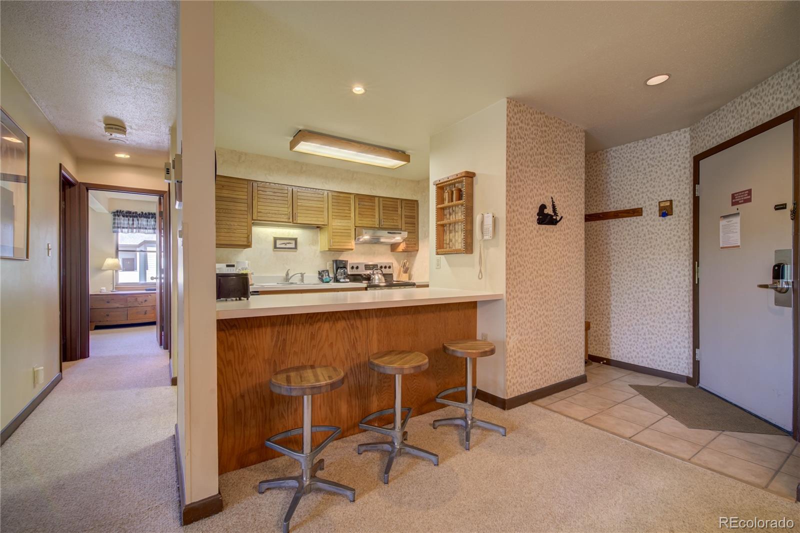 2015 Walton Creek Road, Unit 114 Steamboat Springs, CO 80487 - Photo 10 of 29 a dining hall with stainless steel appliances kitchen island granite countertop a refrigerator and cabinets