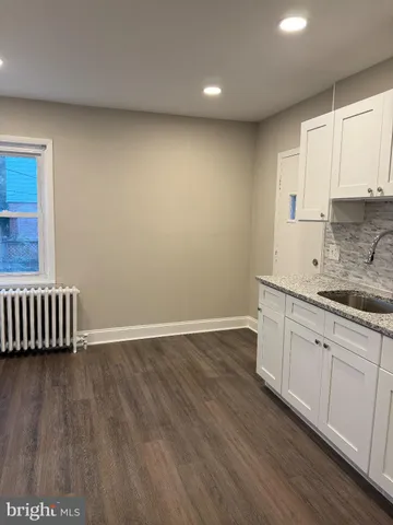 a view of a kitchen with wooden floor and a sink