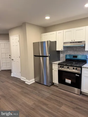 a kitchen with a refrigerator stove and wooden cabinets