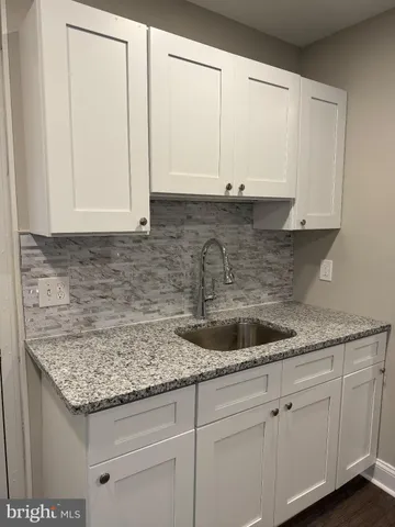 a kitchen with granite countertop a sink and cabinets