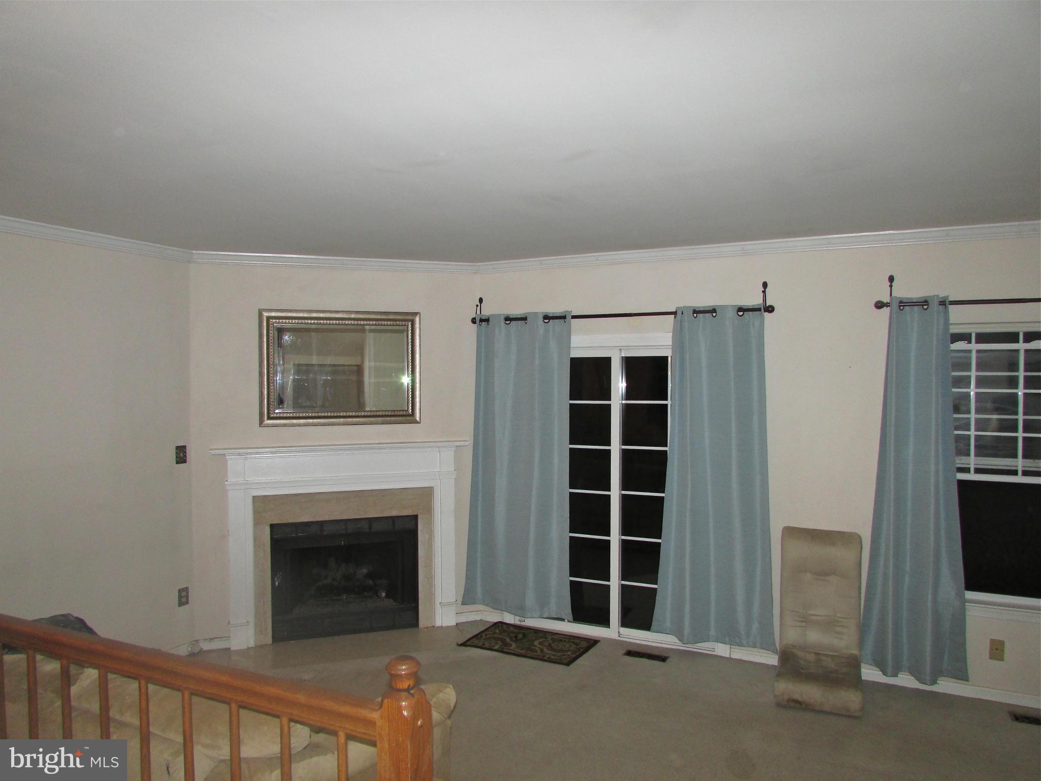 6808 Compton Valley Place Centreville, VA 20121 - Photo 11 of 16 a view of an empty room with a fireplace and window