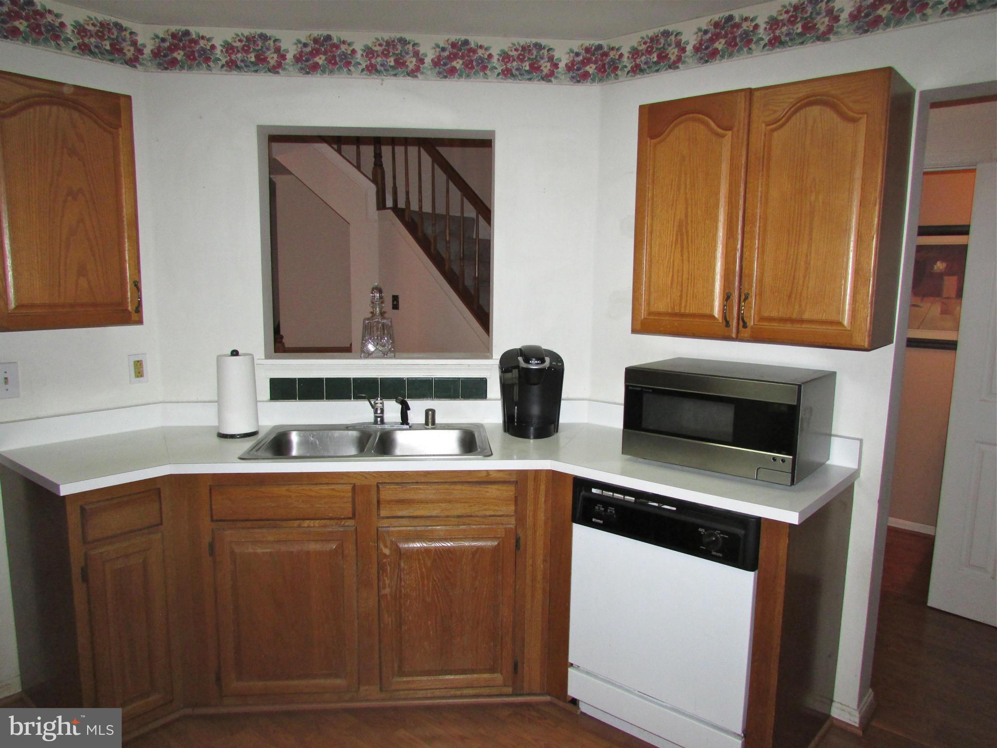 6808 Compton Valley Place Centreville, VA 20121 - Photo 4 of 16 a kitchen with a sink and cabinets