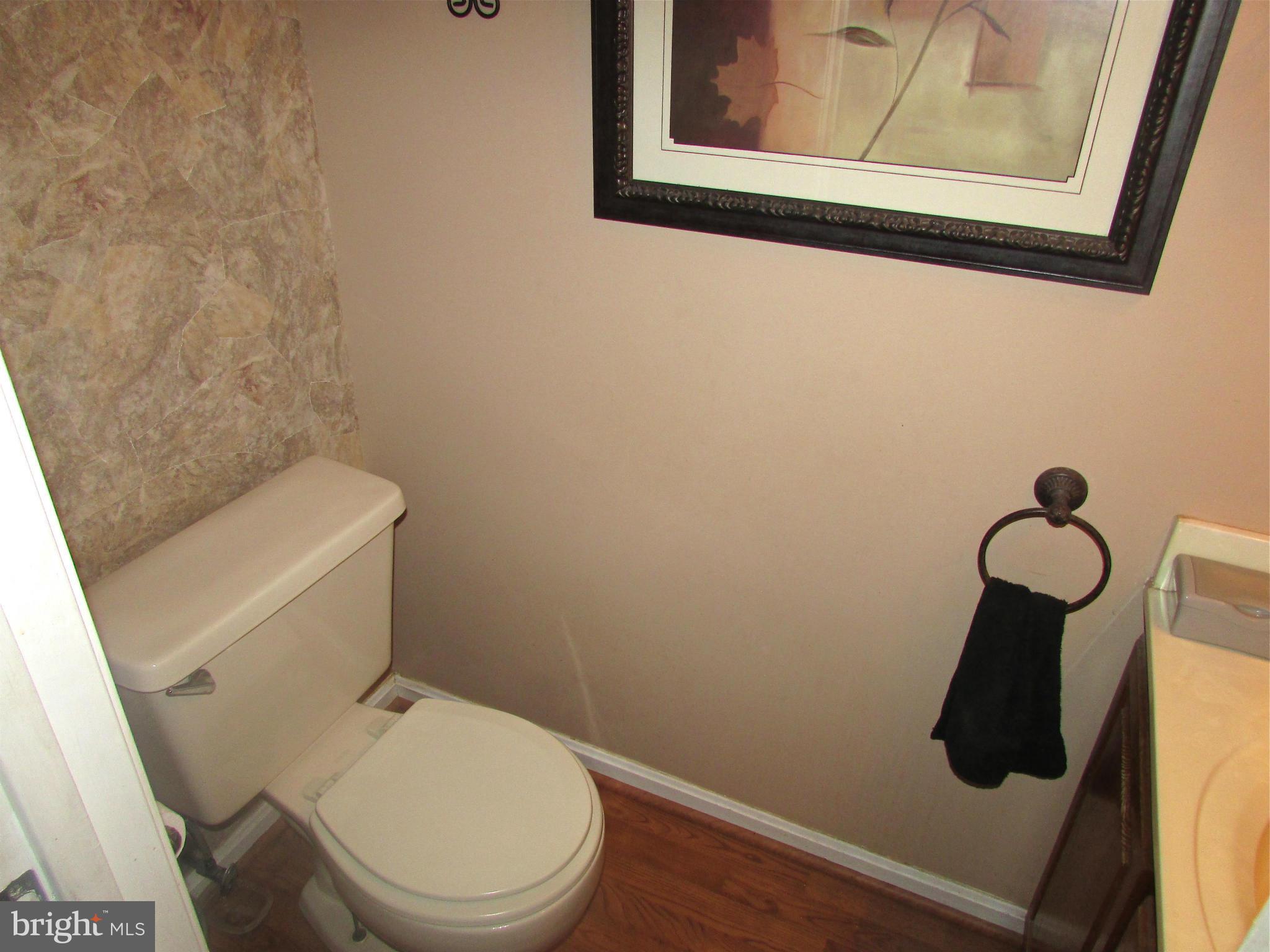 6808 Compton Valley Place Centreville, VA 20121 - Photo 6 of 16 a white toilet sitting next to a wooden cabinet