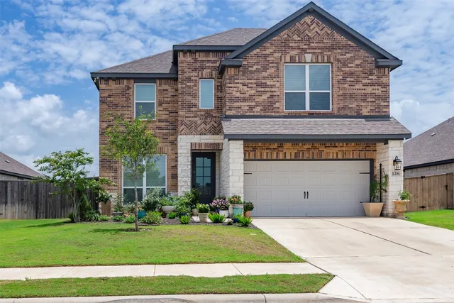 a front view of a house with a garden and plants