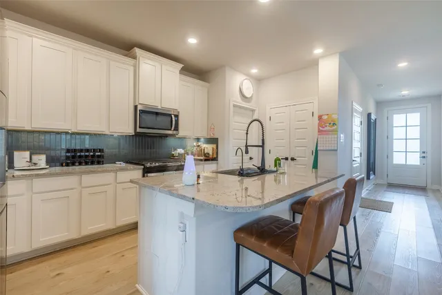 a kitchen with sink a microwave and cabinets
