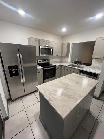 a kitchen with stainless steel appliances a refrigerator sink and stove