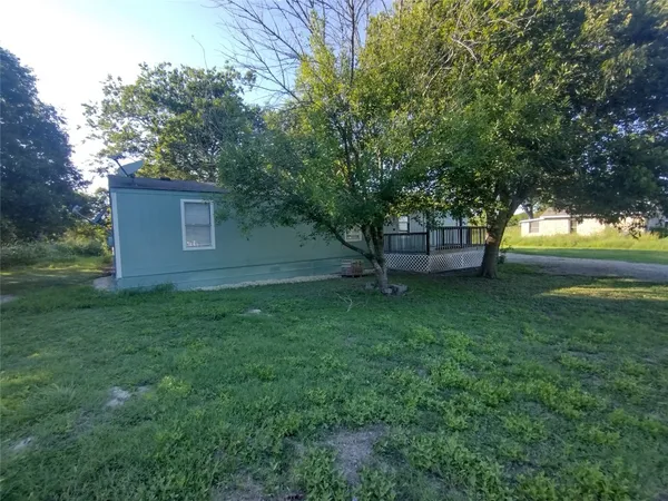 a view of a backyard with large trees