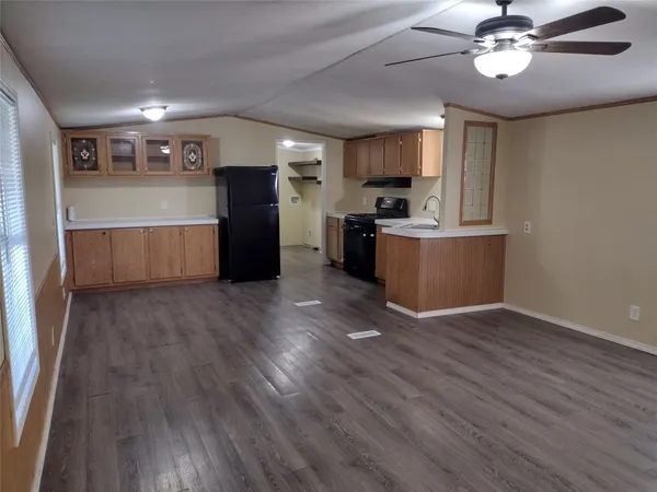 a kitchen with stainless steel appliances a refrigerator oven a sink dishwasher with a dining table and chairs with wooden floor