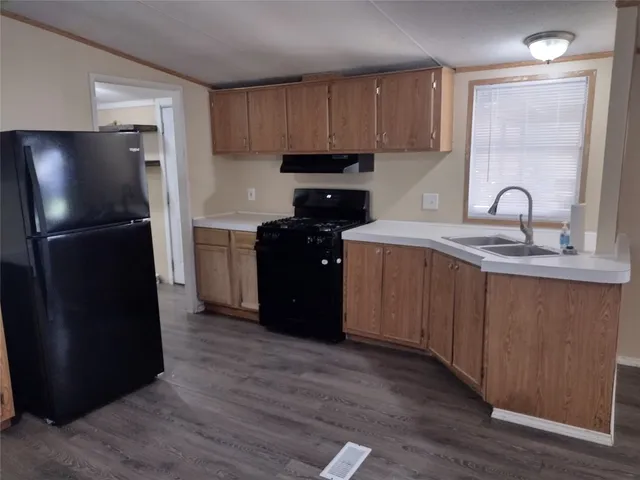 a kitchen with a refrigerator sink and cabinets