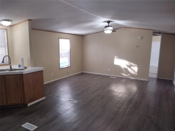 a view of a livingroom with wooden floor and a ceiling fan