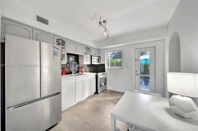 a kitchen with stainless steel appliances a stove a sink and a refrigerator