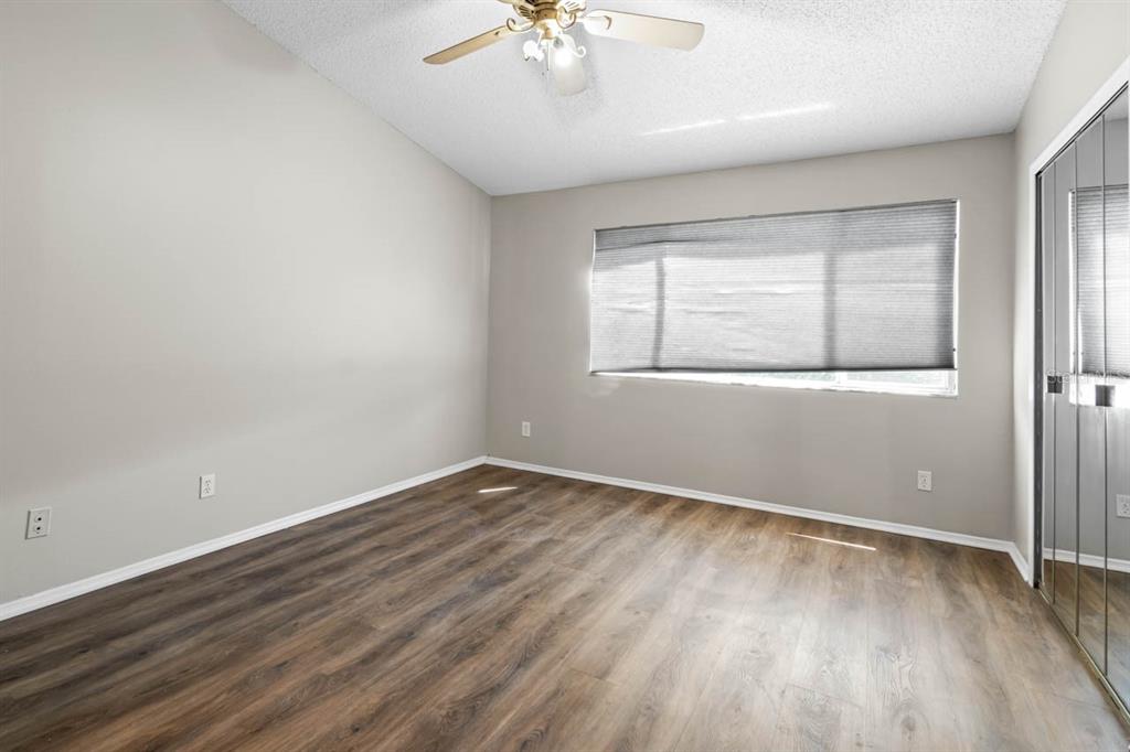 273 Countryside Key Boulevard Oldsmar, FL 34677 - Photo 18 of 32 an empty room with wooden floor chandelier fan and windows