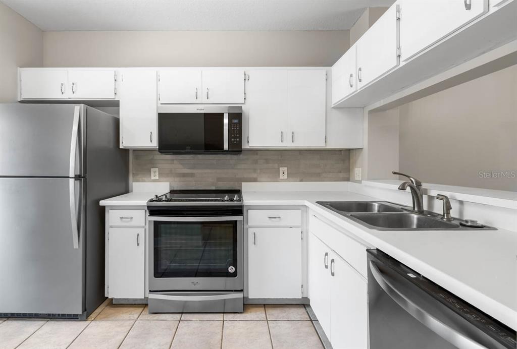 273 Countryside Key Boulevard Oldsmar, FL 34677 - Photo 6 of 32 a kitchen with stainless steel appliances granite countertop a stove microwave and refrigerator