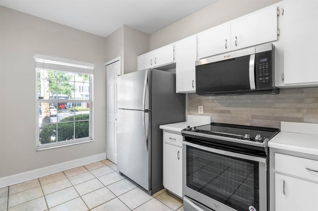 273 Countryside Key Boulevard Oldsmar, FL 34677 - Photo 7 of 32 a kitchen with cabinets stainless steel appliances and a window