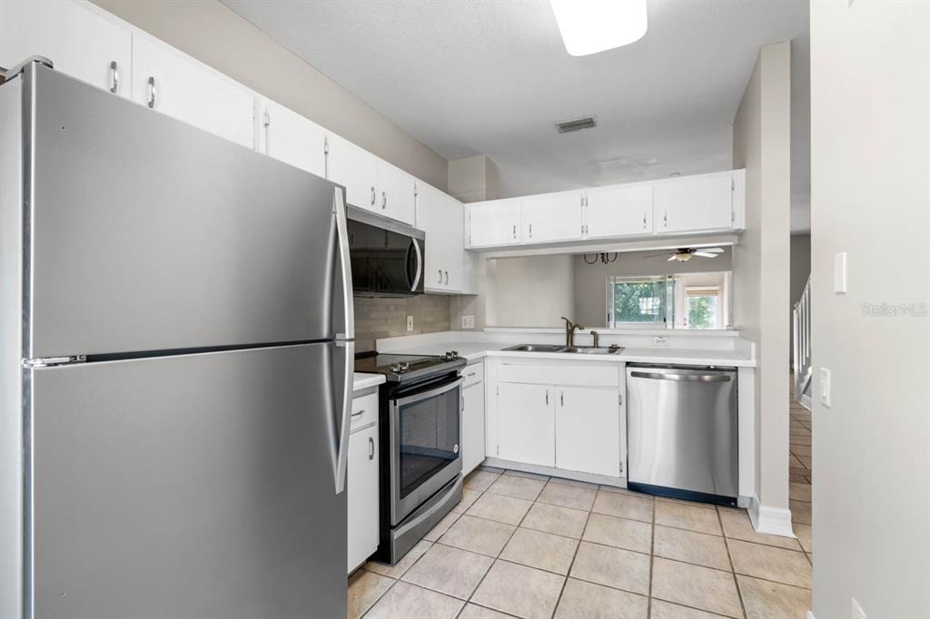 273 Countryside Key Boulevard Oldsmar, FL 34677 - Photo 9 of 32 a kitchen with stainless steel appliances a refrigerator sink and microwave