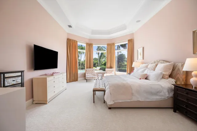 a spacious bedroom with a bed and a flat screen tv