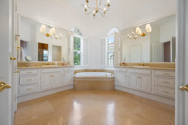 a bathroom with a granite countertop sink a large mirror and a bathtub
