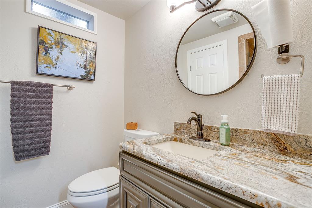 1816 Granada Road Fort Worth, TX 76116 - Photo 30 of 40 a bathroom with a granite countertop toilet a sink and a mirror