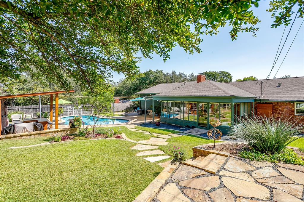 1816 Granada Road Fort Worth, TX 76116 - Photo 35 of 40 a view of a swimming pool with lawn chairs under an umbrella