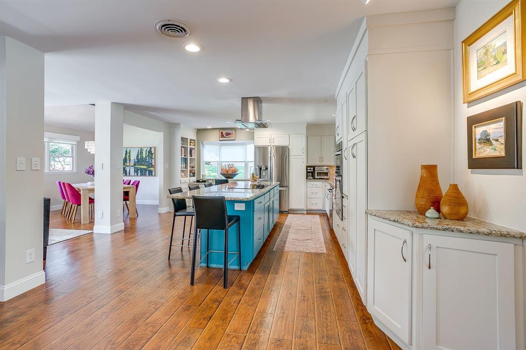 1816 Granada Road Fort Worth, TX 76116 - Photo 8 of 40 a kitchen with stainless steel appliances kitchen island wooden floors stove and white cabinets