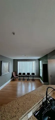 a view of an empty room with window and a ceiling fan