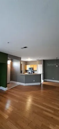 a view of empty room with wooden floor