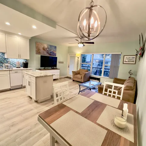 a living room with furniture a chandelier and a flat screen tv