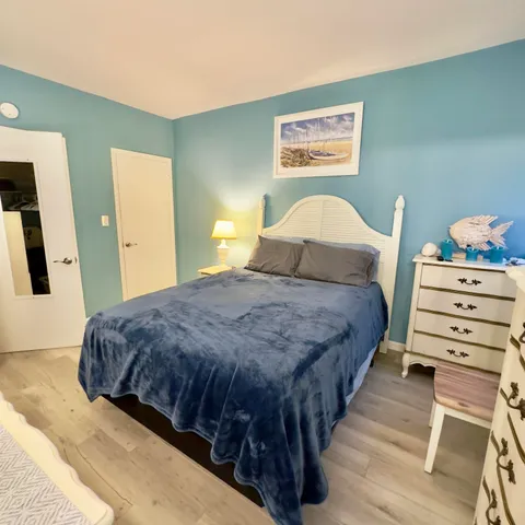 a bedroom with a bed and a flat tv screen on dresser