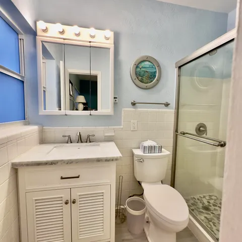 a bathroom with a granite countertop toilet sink and mirror