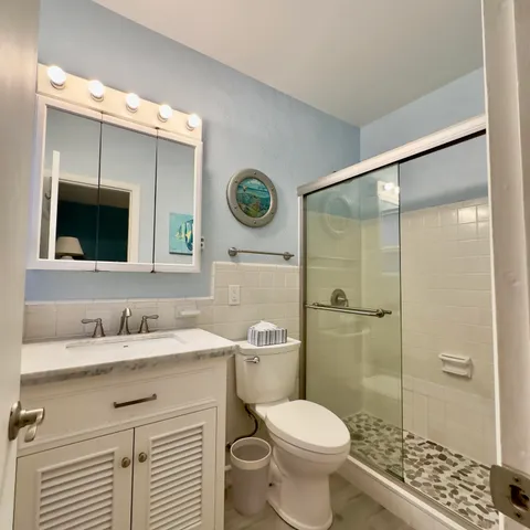 a bathroom with a sink vanity mirror and toilet